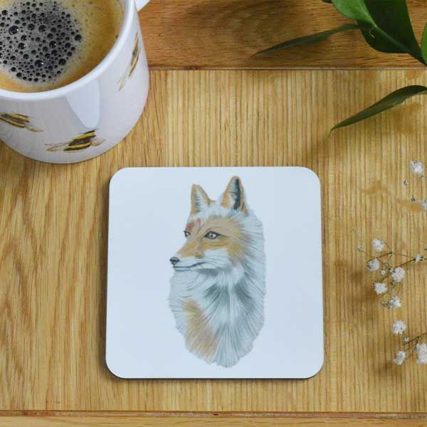 A white coaster with a picture of a fox by Liz Corley Art